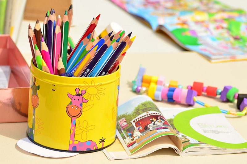 Kindergarten Ein Schreibtisch mit bunten Stifte, einem Heft und Spielsachen